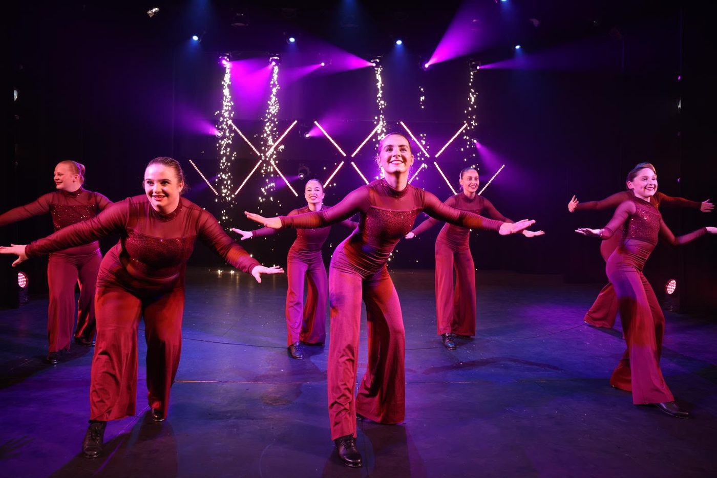 Senior company dancers performing in matching outfits